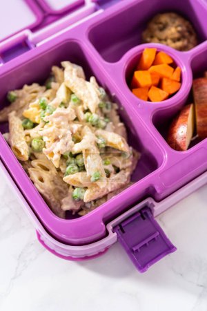 Téléchargez les photos : Boîte à lunch scolaire avec salade de macaronis au poulet et pommes. - en image libre de droit