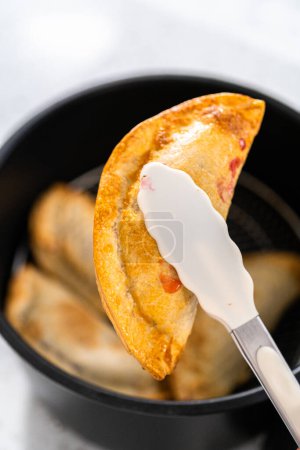 Téléchargez les photos : Faire frire des empanadas de cerises douces dans la friteuse. - en image libre de droit