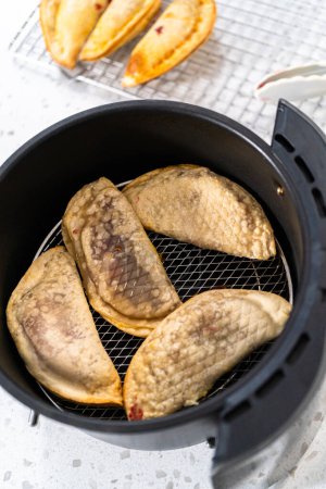 Photo for Frying sweet cherry empanadas in the air fryer. - Royalty Free Image