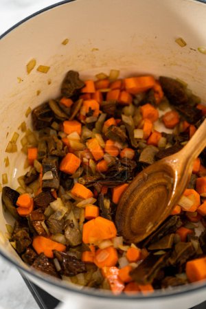 Téléchargez les photos : Soupe crémeuse aux champignons sauvages préparée dans un four hollandais émaillé. - en image libre de droit
