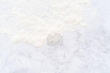 Téléchargez les photos : Farine blanche saupoudrée sur un comptoir de cuisine après cuisson. - en image libre de droit