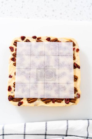 Photo for Scoring white chocolate cranberry pecan fudge for cutting into small pieces. - Royalty Free Image