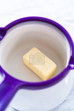 Photo for Melting stick of unsalted butter in candy melting pot. - Royalty Free Image