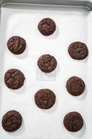 Foto de Enfriamiento de galletas de chocolate recién horneadas en un mostrador de cocina. - Imagen libre de derechos