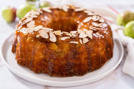 Photo for Freshly baked apple bundt cake with caramel glaze on a white plate. - Royalty Free Image