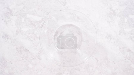 Photo for Flat lay. Step by step. Mixing ingredients in a glass mixing bowl to prepare red velvet bundt cake. - Royalty Free Image