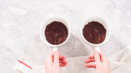 Photo for Flat lay. Step by step. Pouring chocolate cake batter into the cups to prepare chocolate mug cake. - Royalty Free Image