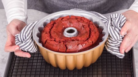 Photo for Step by step. Cooling freshly baked red velvet bundt cake on a kitchen drying rack. - Royalty Free Image