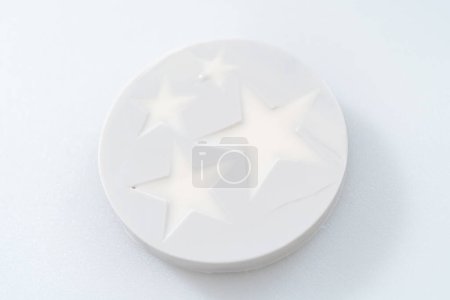 Foto de Llenado de molde de silicona en forma de estrella con chocolate de color derretido. - Imagen libre de derechos