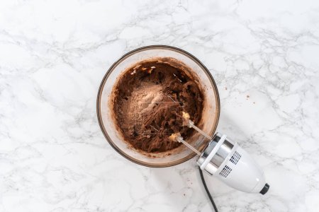 Photo for Flat lay. Mixing ingredients with a hand mixer to bake chocolate cookies with chocolate hearts for Valentines Day. - Royalty Free Image