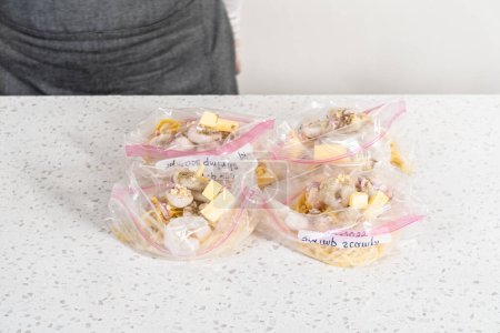 Photo for Packaging homemade frozen shrimp scampi meal prep into plastic resealable bags. - Royalty Free Image