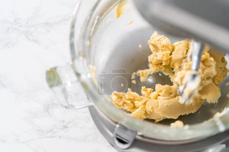 Foto de Mezclar ingredientes en una batidora eléctrica de cocina para hornear galletas de shortbread en forma de panda con hielo de chocolate. - Imagen libre de derechos