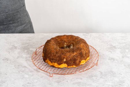Foto de Extracción de la torta de zanahoria recién horneada del molde de la torta para redondear el estante de enfriamiento. - Imagen libre de derechos