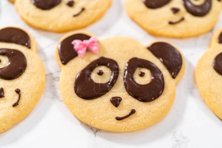 Photo for Panda-shaped shortbread cookies with chocolate icing on the kitchen counter. - Royalty Free Image