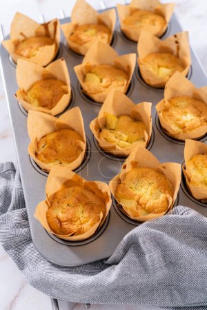 Téléchargez les photos : Refroidissement des muffins sharlotka aux pommes fraîchement cuits sur un comptoir de cuisine. - en image libre de droit