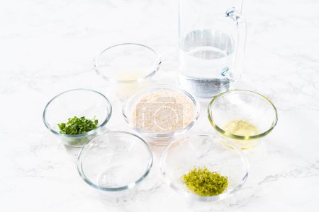 Photo for Cilantro Lime Rice. Measured ingredients in glass mixing bowls to prepare cilantro lime rice. - Royalty Free Image