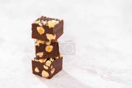 Foto de Piezas cuadradas de chocolate caseras de avellana apiladas en el mostrador de la cocina. - Imagen libre de derechos