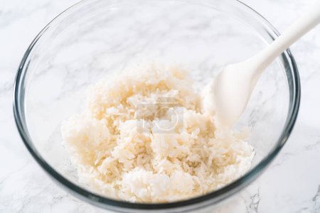Foto de Cilantro Lime Rice. Mezclar los ingredientes en un tazón de vidrio para preparar arroz con cilantro y lima. - Imagen libre de derechos