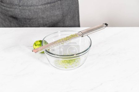 Photo for Zesting fresh lime to prepare chili lime salt for Mexican watermelon pops. - Royalty Free Image