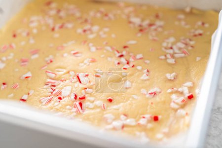 Photo for Removing candy cane fudge from a square cheesecake pan lined with parchment. - Royalty Free Image