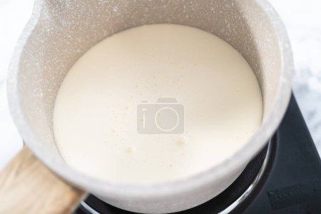 Téléchargez les photos : Préparation de ganache au chocolat dans une petite casserole. - en image libre de droit