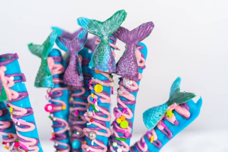 Photo for Mermaid chocolate pretzel rods drizzled with pink and purple chocolate and covered with sprinkles. - Royalty Free Image