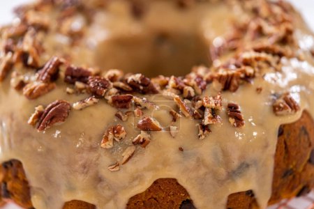 Photo for Frosting pumpkin bundt cake with a toffee glaze and garnish with toasted pecans. - Royalty Free Image