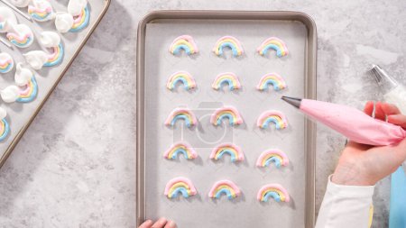 Photo for Flat lay. Step by step. Piping meringue mix into unicorn-shaped pops on a baking sheet lined with parchment paper. - Royalty Free Image