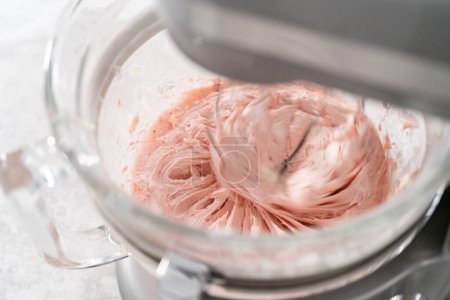 Photo for Whipping strawberry buttercream frosting in a stand-alone electric mixer with a whisk attachment. - Royalty Free Image