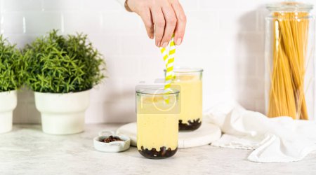 Photo for Pouring mango boba smoothie into the drinking glasses. - Royalty Free Image