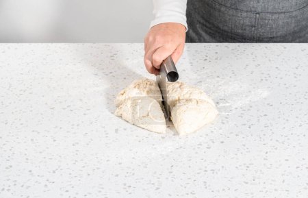 Téléchargez les photos : Rouler la pâte à pain avec un rouleau à pâtisserie français pour cuire les trempettes naan. - en image libre de droit