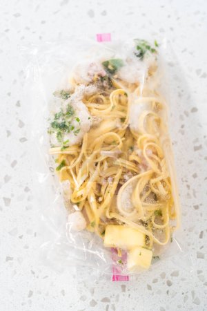 Téléchargez les photos : Préparation des repas. Paquets langoustines aux crevettes avec pâtes dans un plastique arrière pour stocker dans un congélateur. - en image libre de droit