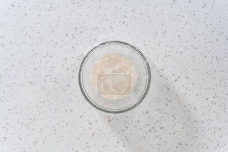 Photo for Flat lay. Activating dry yeast in a glass mixing bowl to bake naan dippers. - Royalty Free Image