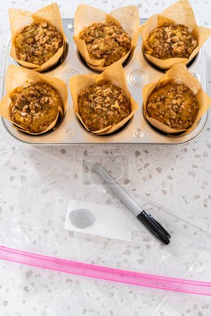 Photo for Meal prepping. Packaging banana oatmeal muffins into the plastic back to store in a freezer. - Royalty Free Image