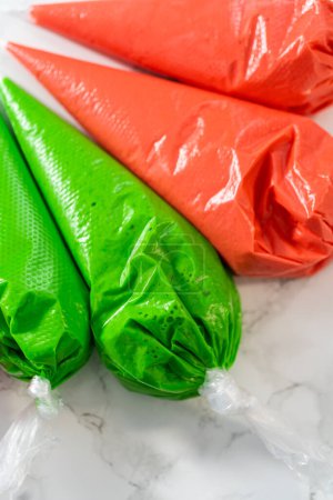 Téléchargez les photos : Cerise royale dans des sacs de tuyauterie pour décorer les biscuits au pain d'épice de Noël. - en image libre de droit