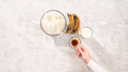 Téléchargez les photos : Flat lay. Step by step. Measured ingredients in glass mixing bowls to prepare coconut banana pancakes for breakfast. - en image libre de droit