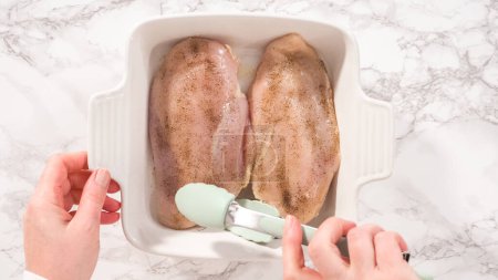 Téléchargez les photos : Pose plate. Pas à pas. Assaisonnement poulet avec sel et poivre pour la cuisson dans un plat de cuisson. - en image libre de droit