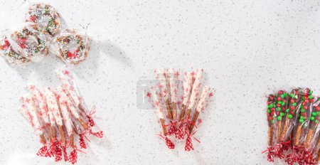 Photo for Denver, Colorado, USA-December 18, 2022-Flat lay. Packaging homemade chocolate-covered pretzels into clear plastic bags for Christmas gifts. - Royalty Free Image