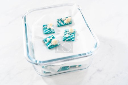 Photo for Packaging mini mermaid chocolate bars into a food glass container for storage. - Royalty Free Image