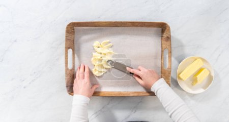 Téléchargez les photos : Pose plate. Étaler du beurre non salé à température ambiante pour préparer une planche de beurre végétarienne pour une fête. - en image libre de droit