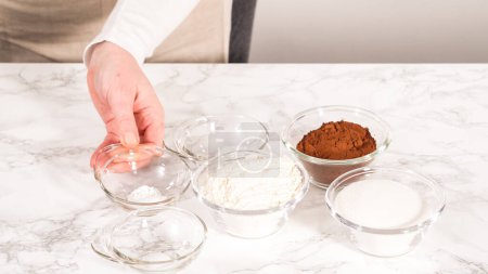 Photo for Step by step. Measured ingredients in glass mixing bowls to prepare chocolate cupcake. - Royalty Free Image