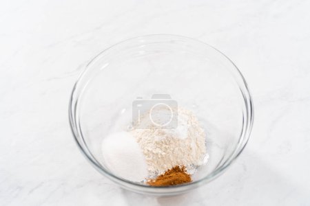 Photo for Mixing ingredients in a glass mixing bowl to prepare pumpkin mug cake. - Royalty Free Image