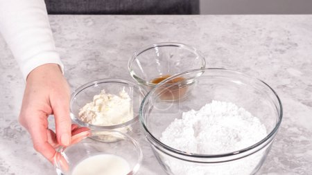 Téléchargez les photos : Pas à pas. Ingrédients dans un bol à mélanger en verre pour préparer le glaçage au fromage à la crème. - en image libre de droit
