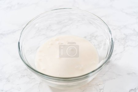 Foto de Mezclar ingredientes en un tazón de vidrio grande para hacer hielo real casero. - Imagen libre de derechos