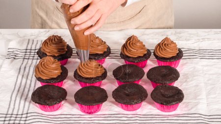 Photo for Step by step. Piping chocolate ganache frosting on top of chocolate cupcakes. - Royalty Free Image