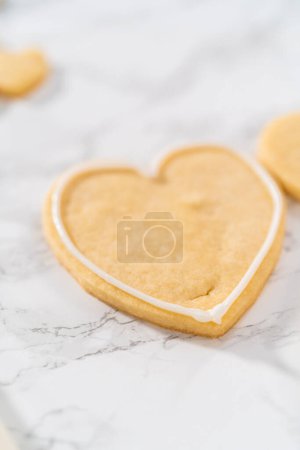 Foto de Decoración de galletas de azúcar en forma de corazón con glaseado real rosa y blanco para el Día de San Valentín. - Imagen libre de derechos