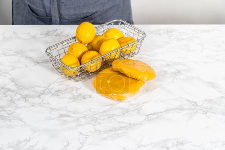 Foto de Galletas de cuña de limón con glaseado de limón. Envolver masa de galletas para enfriar en el refrigerador para hornear galletas de cuña de limón con glaseado de limón. - Imagen libre de derechos