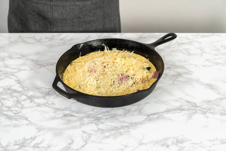 Téléchargez les photos : Step by step. Preparing spinach and ham frittata in cast iron skillet. - en image libre de droit