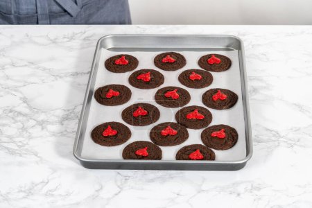 Photo for Decorating chocolate cookies with red chocolate hearts. - Royalty Free Image