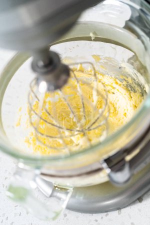 Foto de Azotar los ingredientes en una batidora eléctrica para hacer glaseado de crema de mantequilla dulce de leche. - Imagen libre de derechos